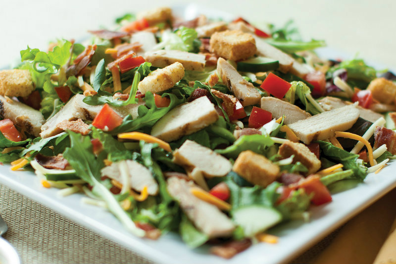 salad with slices of chicken, carrots and pieces of red tomatoes
